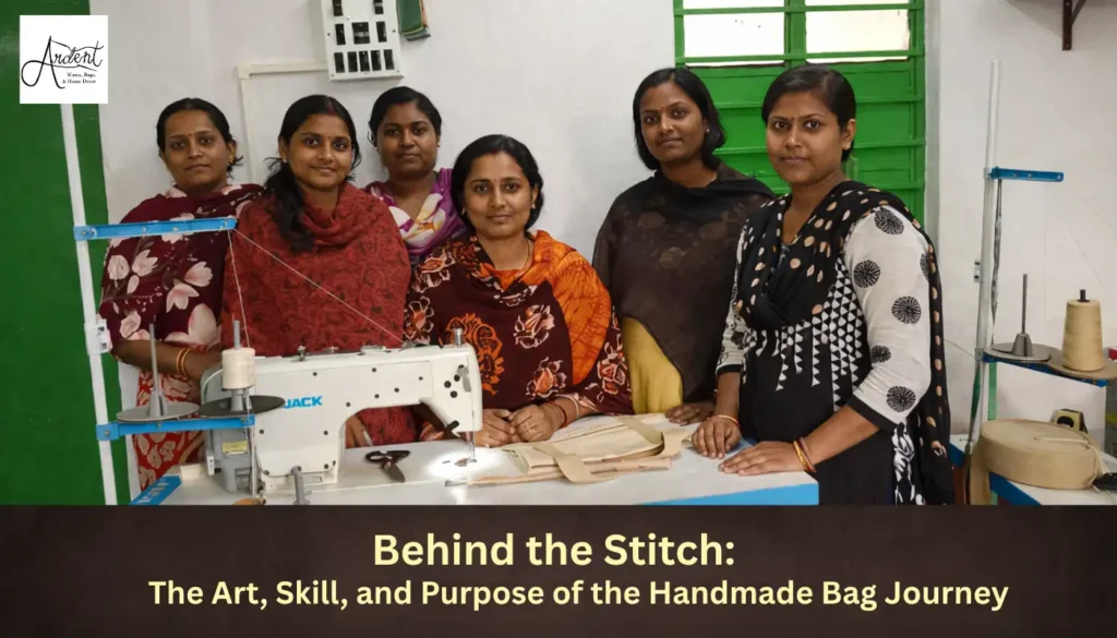 A group of six female artisans smiling together behind a white Jack sewing machine, showcasing the community behind the handmade bag journey.